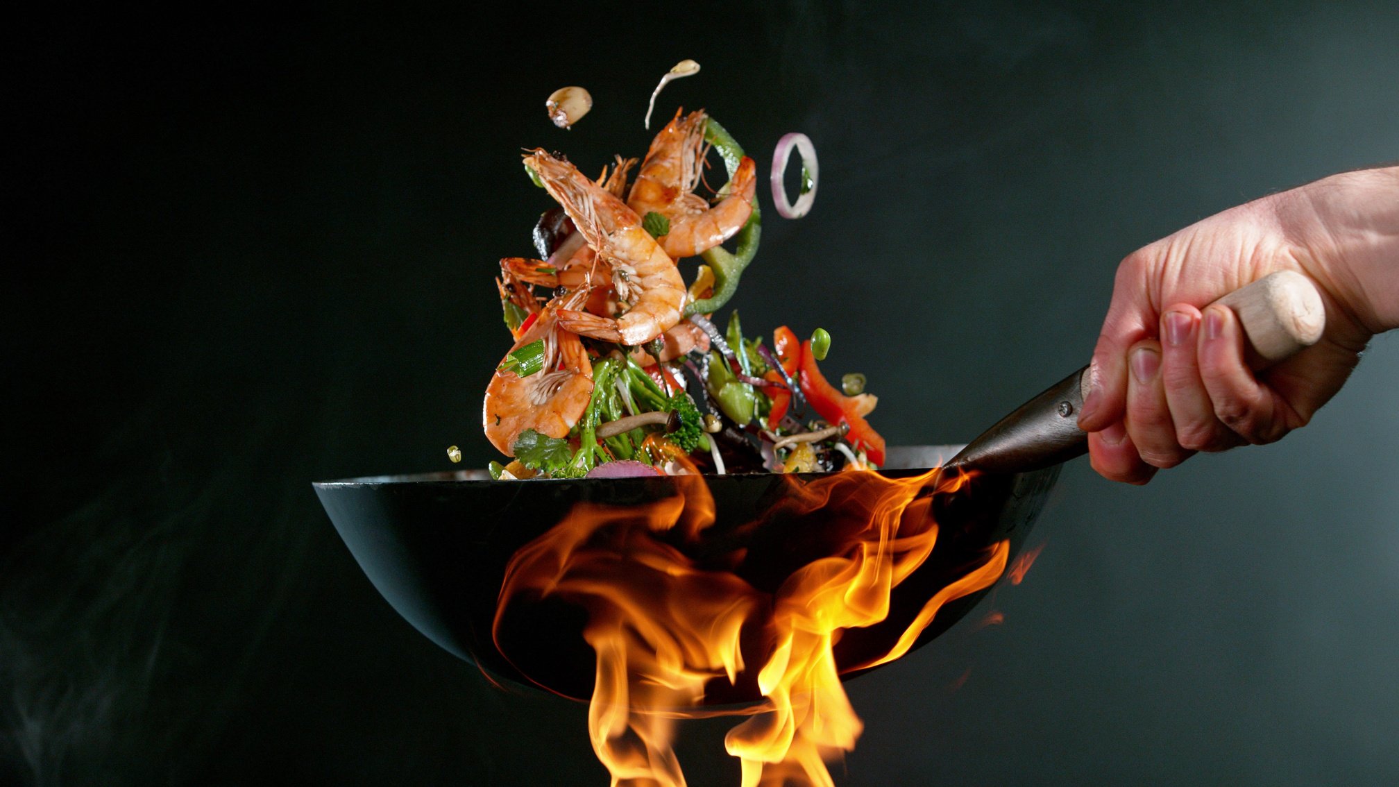 Closeup of Chef Throwing Prawns from Wok Pan in Fire.